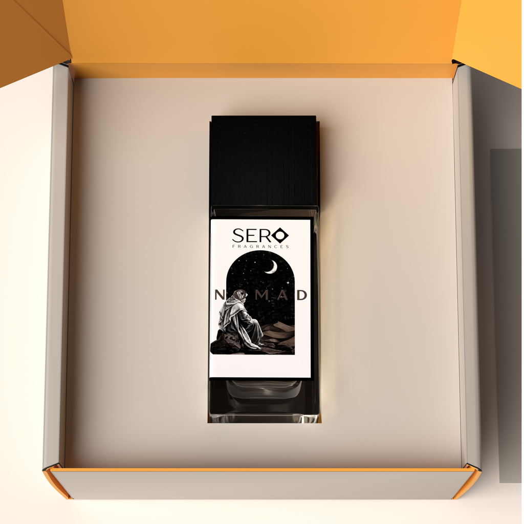Top view of a packaging within it a minimalist clear glass perfume bottle with black wood cap containing SERO fragrance inspired by LV Ombre Nomad. 